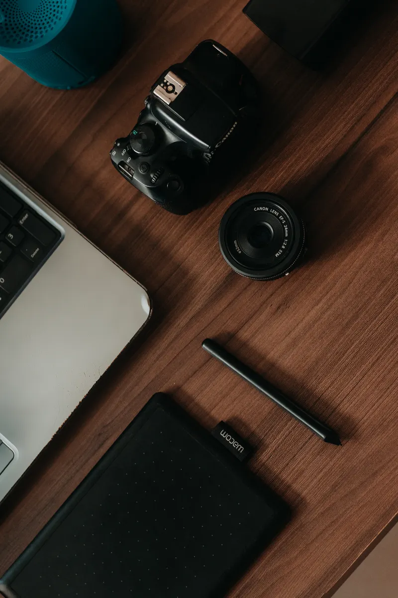 A desk laid out flat with a tablet, stylus, colour swatches, and a keyboard.