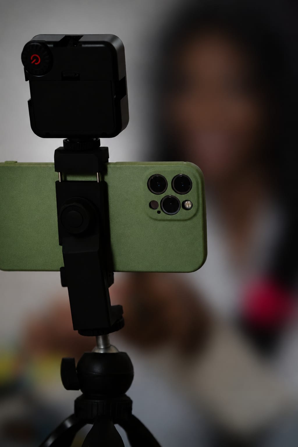 A phone mounted on a tripod between two ring lights.